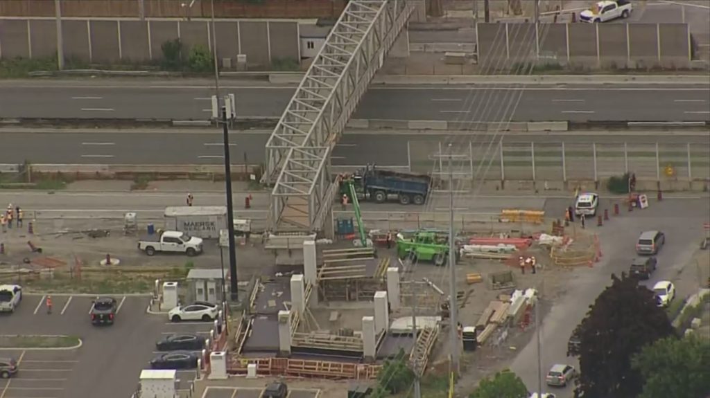 Dump truck hits pedestrian bridge under construction in Mississauga; highway closed between Dixie and Cawthra