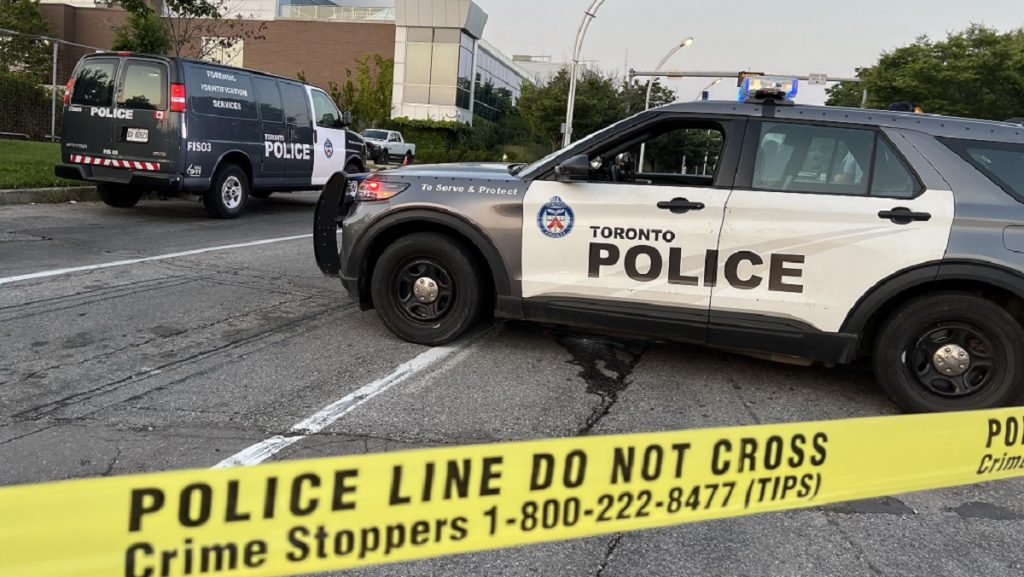 Toronto police officers block off part of British Columbia Road near Lake Shore Boulevard West Sunday evening after shots were fired at a truck.