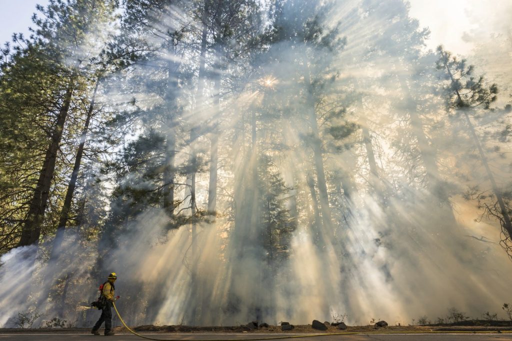 Crews battle wildfires across the US West and fight to hold containment