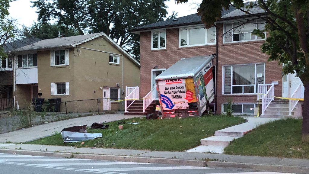 Police investigate after a U-Haul moving van crashed into the front of a house in Rexdale. 