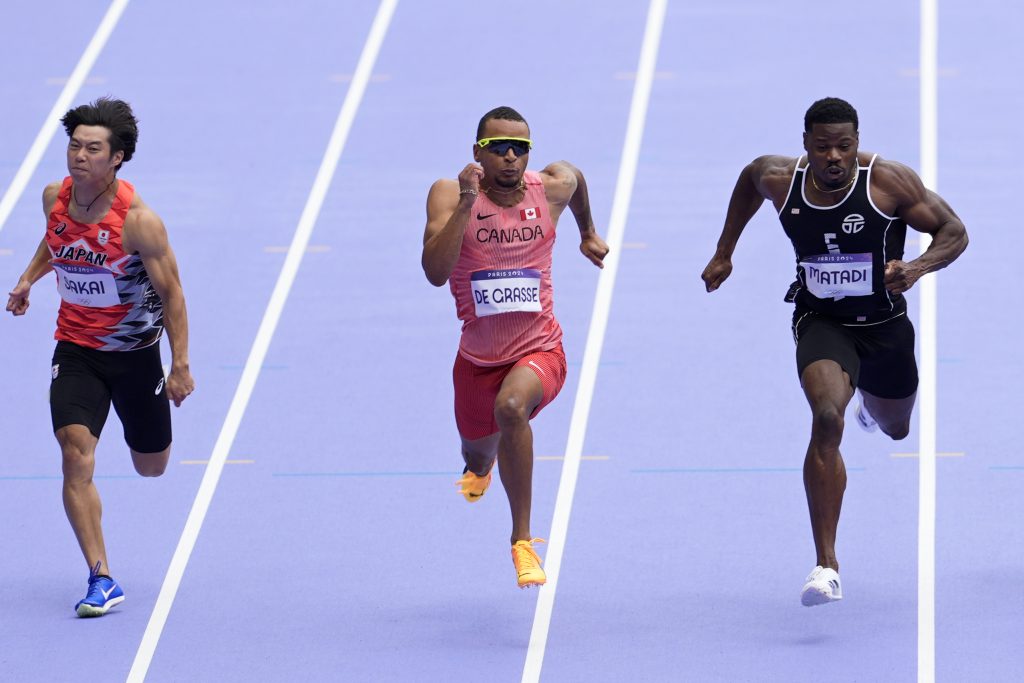 Andre de Grasse, of Canada, crosses the finish line to qualify in a men's 100 meters round 1 heat at the 2024 Summer Olympics, Saturday, Aug. 3, 2024, in Saint-Denis, France.