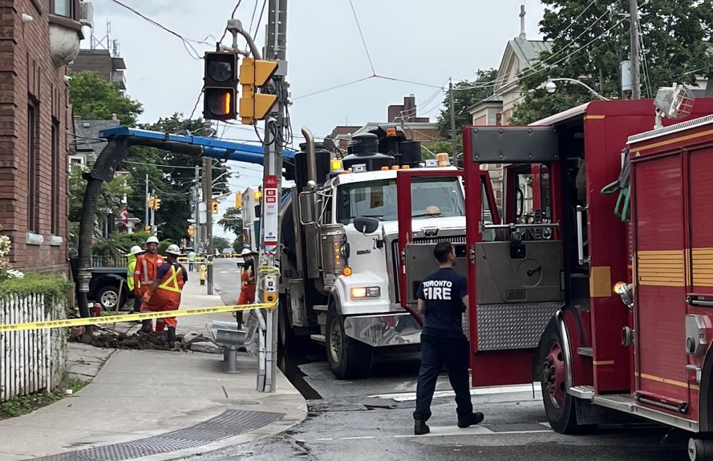 Toronto firefighters are seen outside a home on King Street West after a vehicle crashed into it.