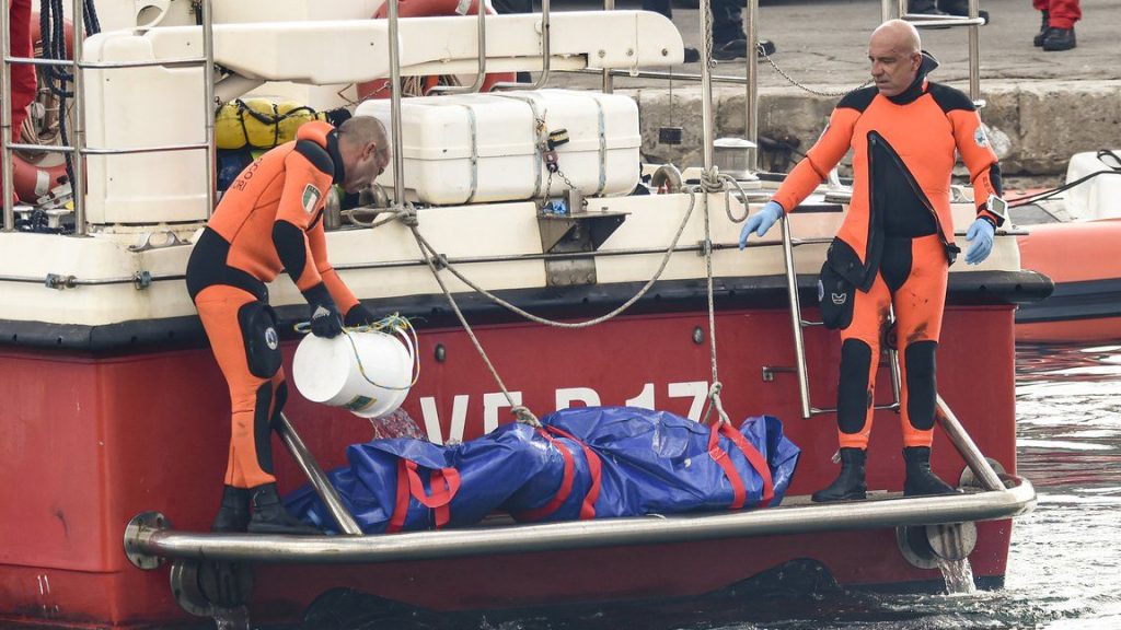 Italian firefighter divers bring ashore in a plastic bag the body of one of the victims of a shipwreck