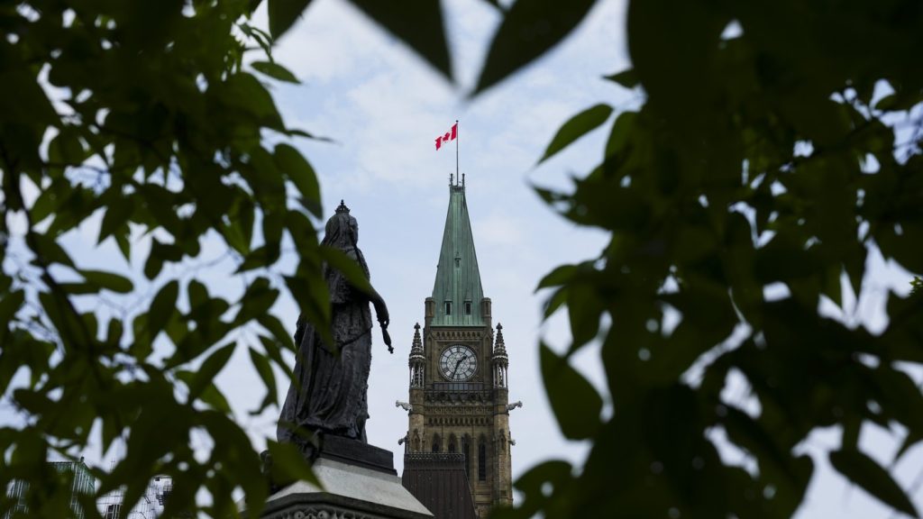 The Peace Tower on Parliament Hill is framed by leaves in Ottawa on Aug. 27, 2024