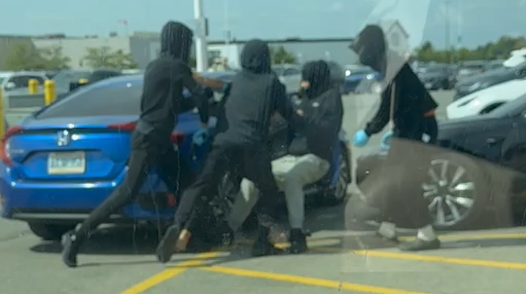 Video still showing four suspects attempting to kidnap a woman from Vaughan Mills parking lot