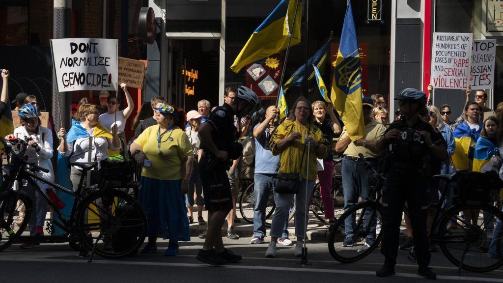 People protest outside of Scotiabank Theatre about the documentary "Russians at War"