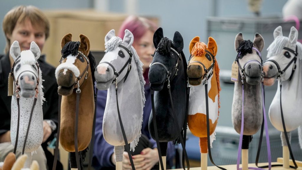 A vendor offers hobby horses for sale