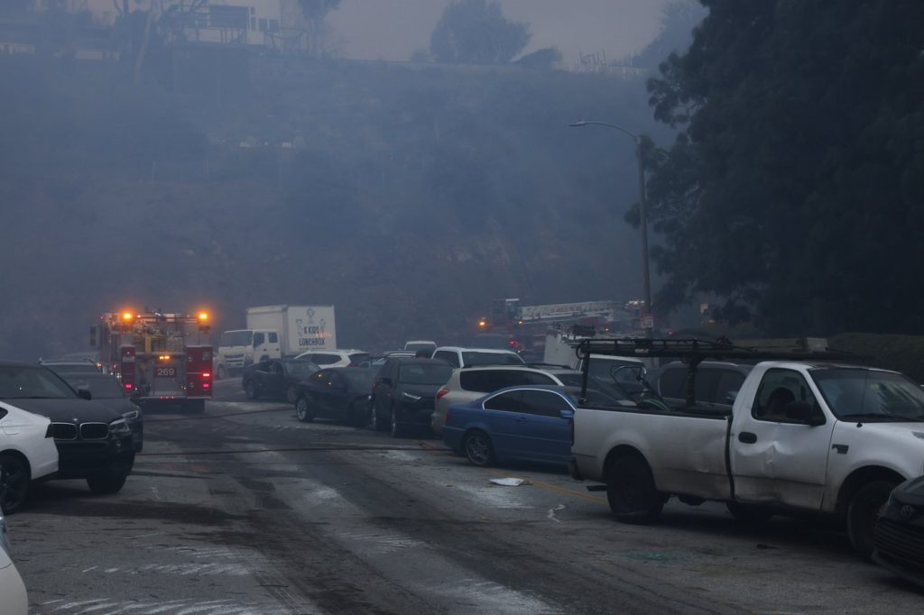 Vehicles are left stranded off the side of the road after residents tried to flee from the Palisades Fire in the Pacific Palisades neighborhood of Los Angeles, Tuesday, Jan. 7, 2025.