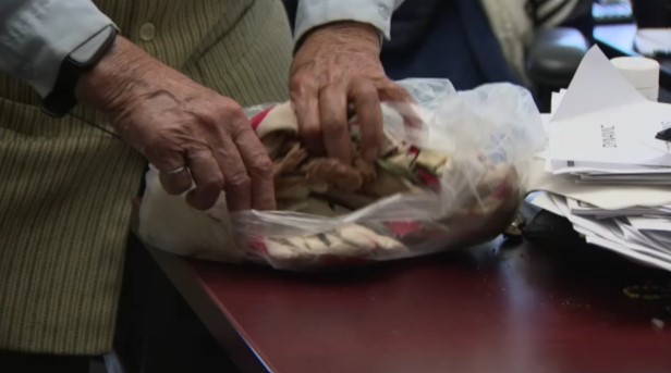 महेश शर्मा एक पारदर्शी प्लास्टिक बैग खोलते हैं, जिसमें फ्लाइट 182 में सवार उनकी मृत बेटी का सामान दिखाई देता है।)