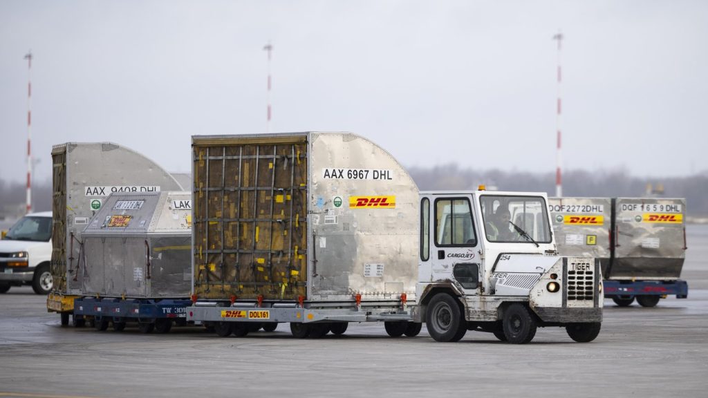 DHL containers are transported on the tarmac at John C. Munro Hamilton International Airport in Hamilton, Ont., Wednesday, March 26, 2025. THE CANADIAN PRESS/Nick Iwanyshyn