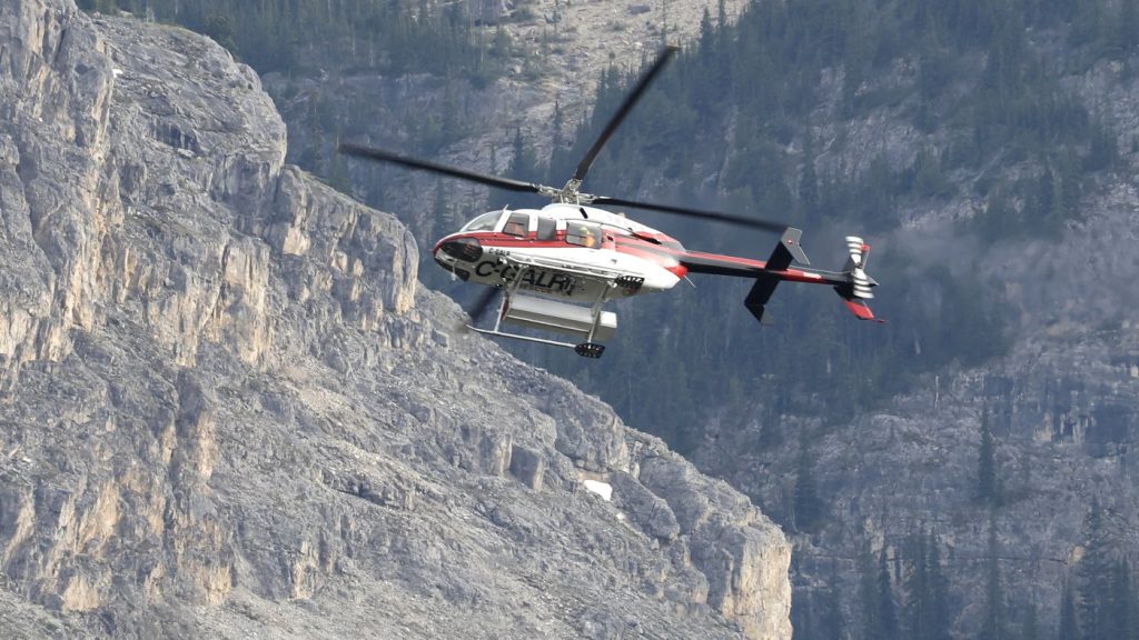 A helicopter is shown close to the scene of a rock slide near Bow Glacier Falls north of Lake Louise, Alta. in Banff National Park on Thursday, June 19, 2025. THE CANADIAN PRESS/Larry MacDougal