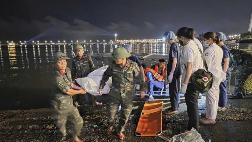 This image from a video provided by QDND shows a body being carried on stretcher after a tourist boat capsized in Ha Long Bay, Vietnam on Saturday, July 19, 2025. (QDND via AP) 