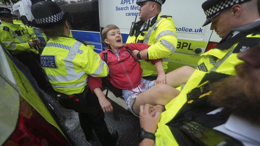 Metropolitan Police officers carry a person from a protest in Parliament Square in support of Palestine Action, organised by Defend Our Juries who are campaigning to de-proscribe the organisation, in London, Saturday July 19, 2025. (Yui Mok/PA via AP) 