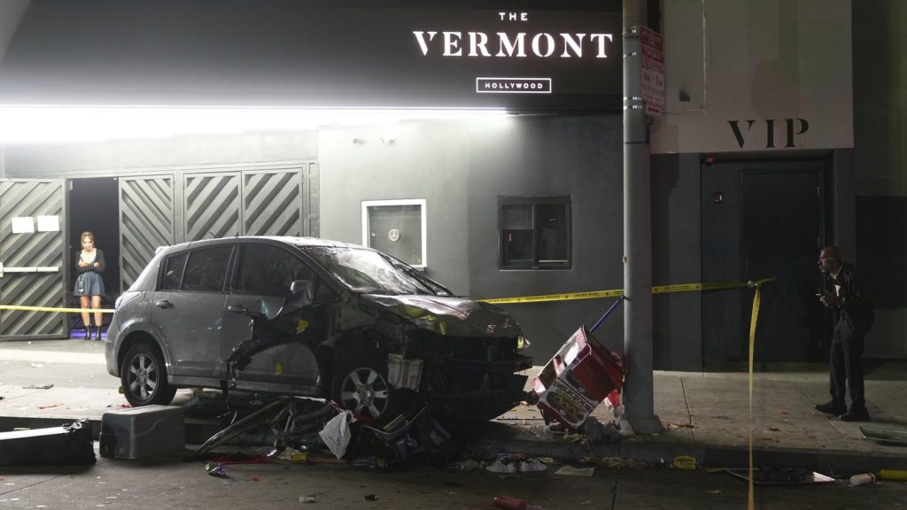 A vehicle sits on the sidewalk after ramming into a crowd of people waiting to enter a nightclub along a busy boulevard in Los Angeles early Saturday, July 19, 2025 injuring several people. (AP Photo/Damian Dovarganes)