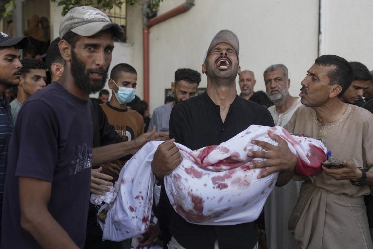 A Palestinian man carries the body of his child, who was killed in an Israeli military airstrike on Gaza, at Shifa Hospital in Gaza City, Saturday, July 12, 2025. (AP Photo/Jehad Alshrafi) 