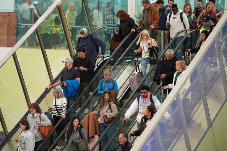 Travellers head tdown an escalator after clearing through a security checkpoint in Denver International Airport Friday, Nov. 7, 2025, in Denver. (AP Photo/David Zalubowski) 
