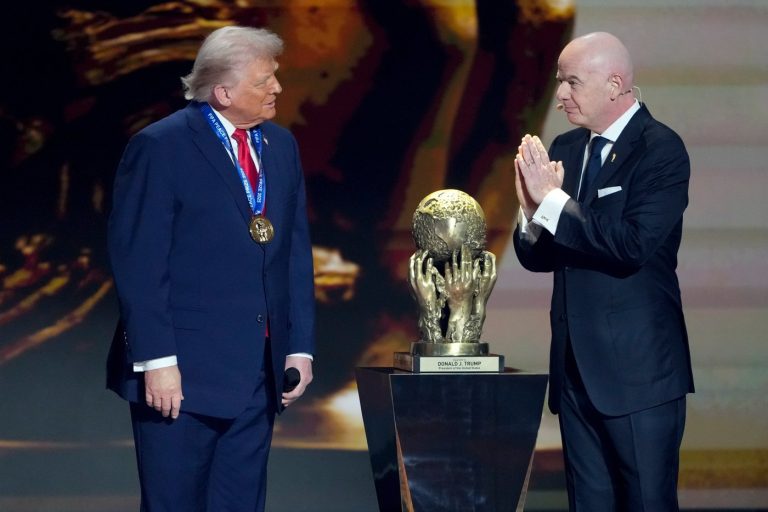 FIFA President Gianni Infantino, right, awards President Donald Trump with the FIFA Peace Prize during the draw for the 2026 soccer World Cup at the Kennedy Center in Washington, Friday, Dec. 5, 2025. (AP Photo/Chris Carlson) 