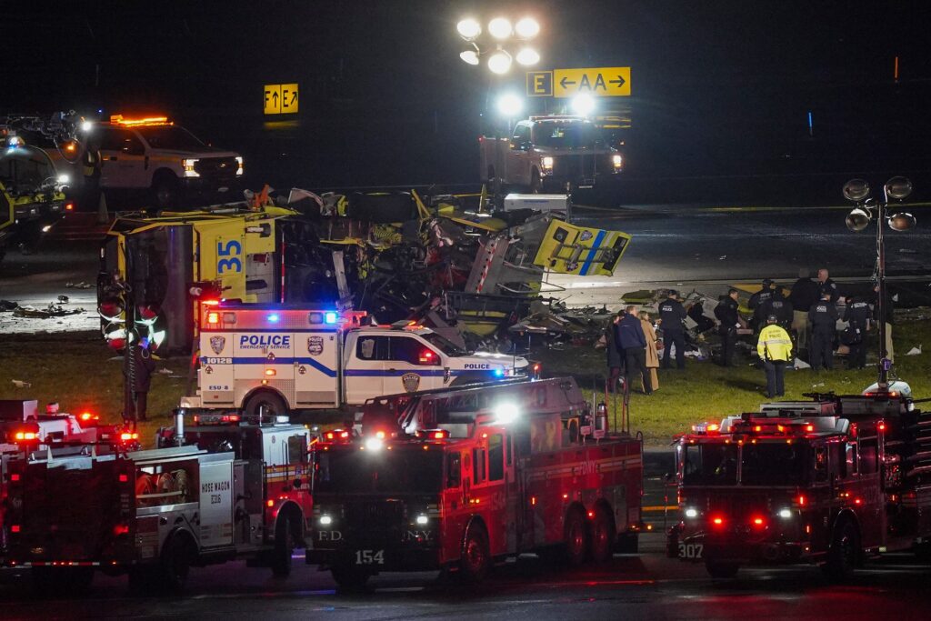 A Port Authority aircraft rescue and firefighting vehicle lays on its side off of runway 4 after colliding with an Air Canada jet after it landed at LaGuardia Airport, Monday, March 23, 2026, in New York