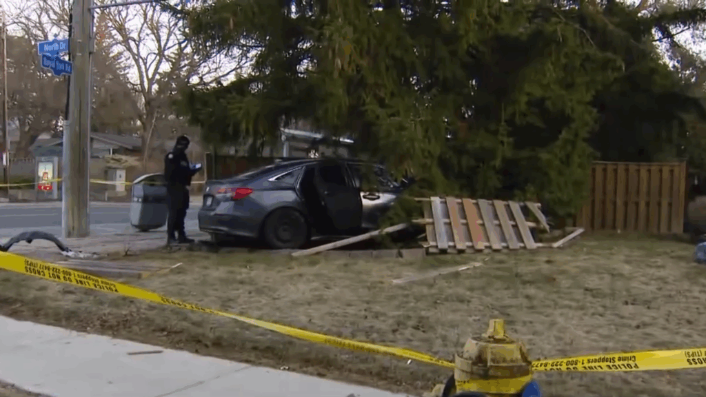 Photos from the scene show a heavily damaged vehicle resting in the front yard of a home near Royal York Road and North Drive, south of Eglinton Avenue West. Photo: CityNews.