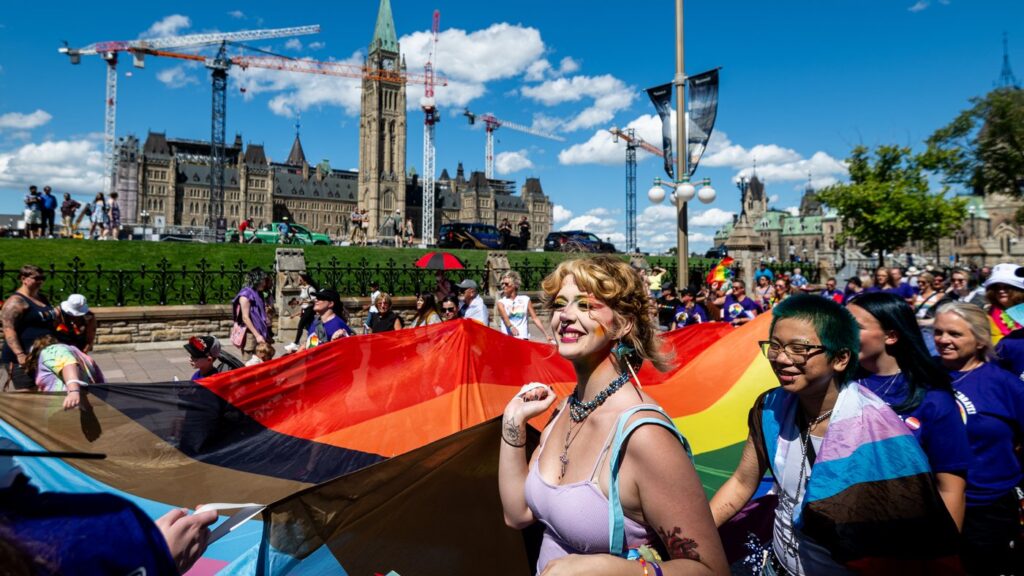 Capital Pride Parade attendees representing the Ottawa Carleton District School Board (OCDSB) hold a large rainbow flag near Parliament Hill during the Capital Pride Parade in Ottawa, on Sunday, Aug. 24, 2025. THE CANADIAN PRESS/Spencer Colby