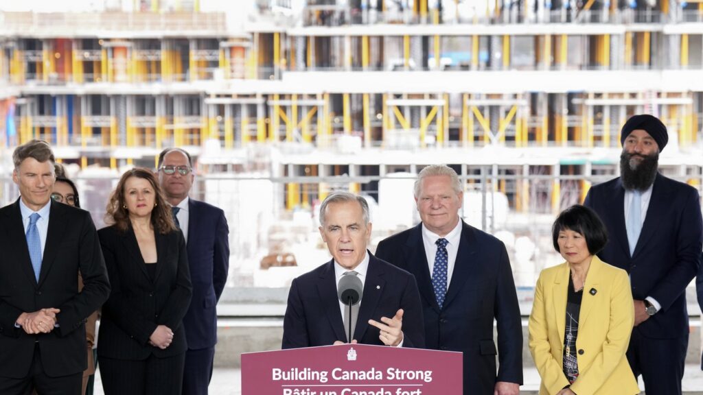 Prime Minister Mark Carney, centre, makes an announcement regarding housing and affordability at a new condo development in Toronto on Monday, March 30, 2026. THE CANADIAN PRESS/Nathan Denette