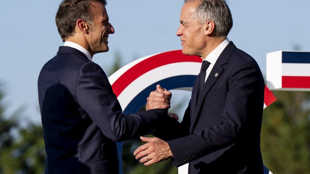 Prime Minister Mark Carney, right, is greeted Emmanuel Macron, President of France, during the G7 summit in Evian-les-Bains, France on Monday, June 15, 2026. THE CANADIAN PRESS/Christopher Katsarov
